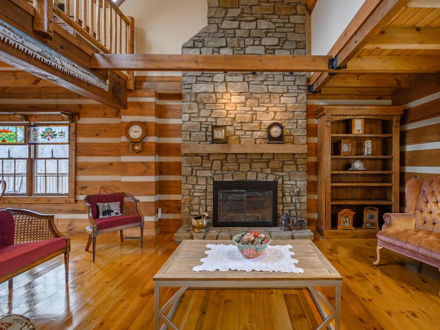 A spacious log-walled great room with a big stone fireplace, timber ceiling and comfortable armchairs